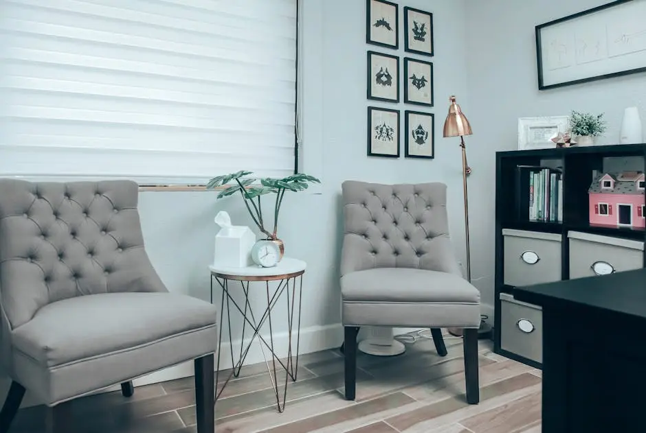 A stylish living room with elegant chairs, decor, and a bookshelf in a modern setting.