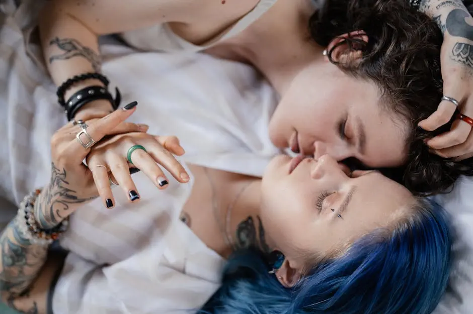 Tender moment of a tattooed couple lying in bed, embracing with love and tranquility.