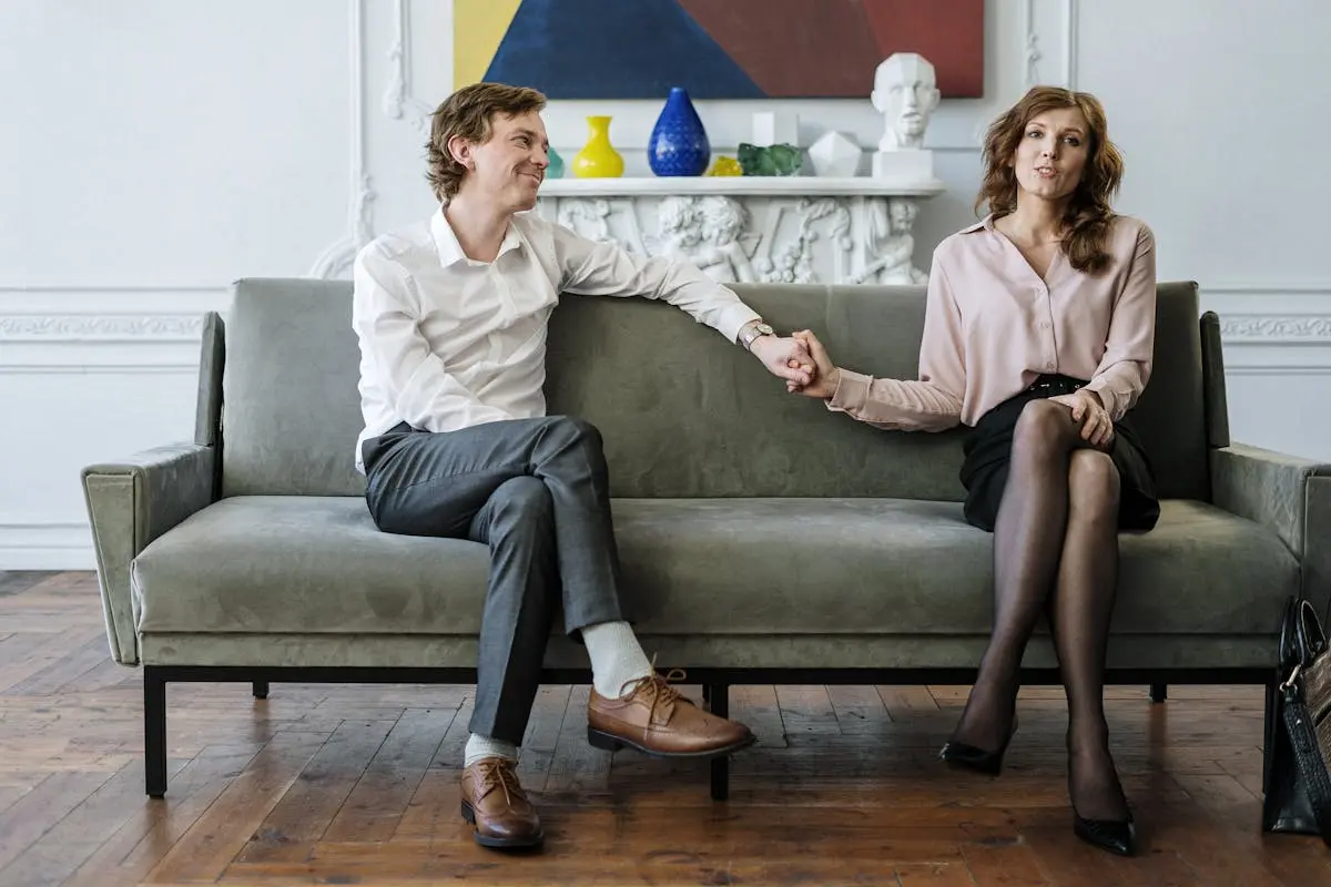 A couple in a therapy session holding hands, conveying support and connection.