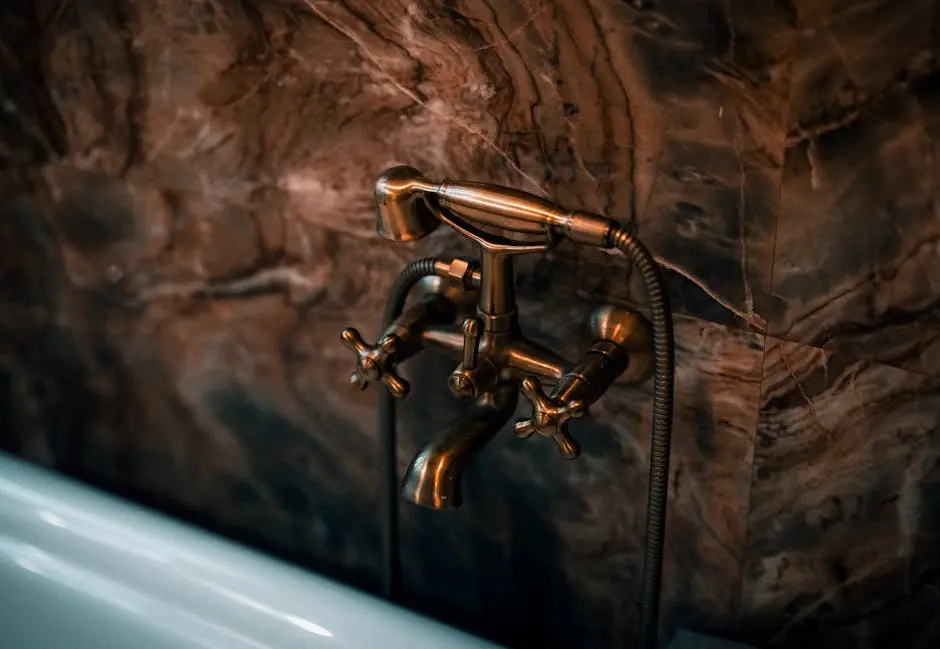 Elegant brass faucet fixture with a luxurious marble wall background.