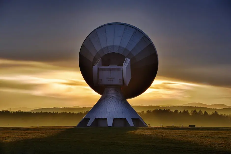 Large satellite dish silhouette against a colorful sunset, showcasing broadcasting technology.