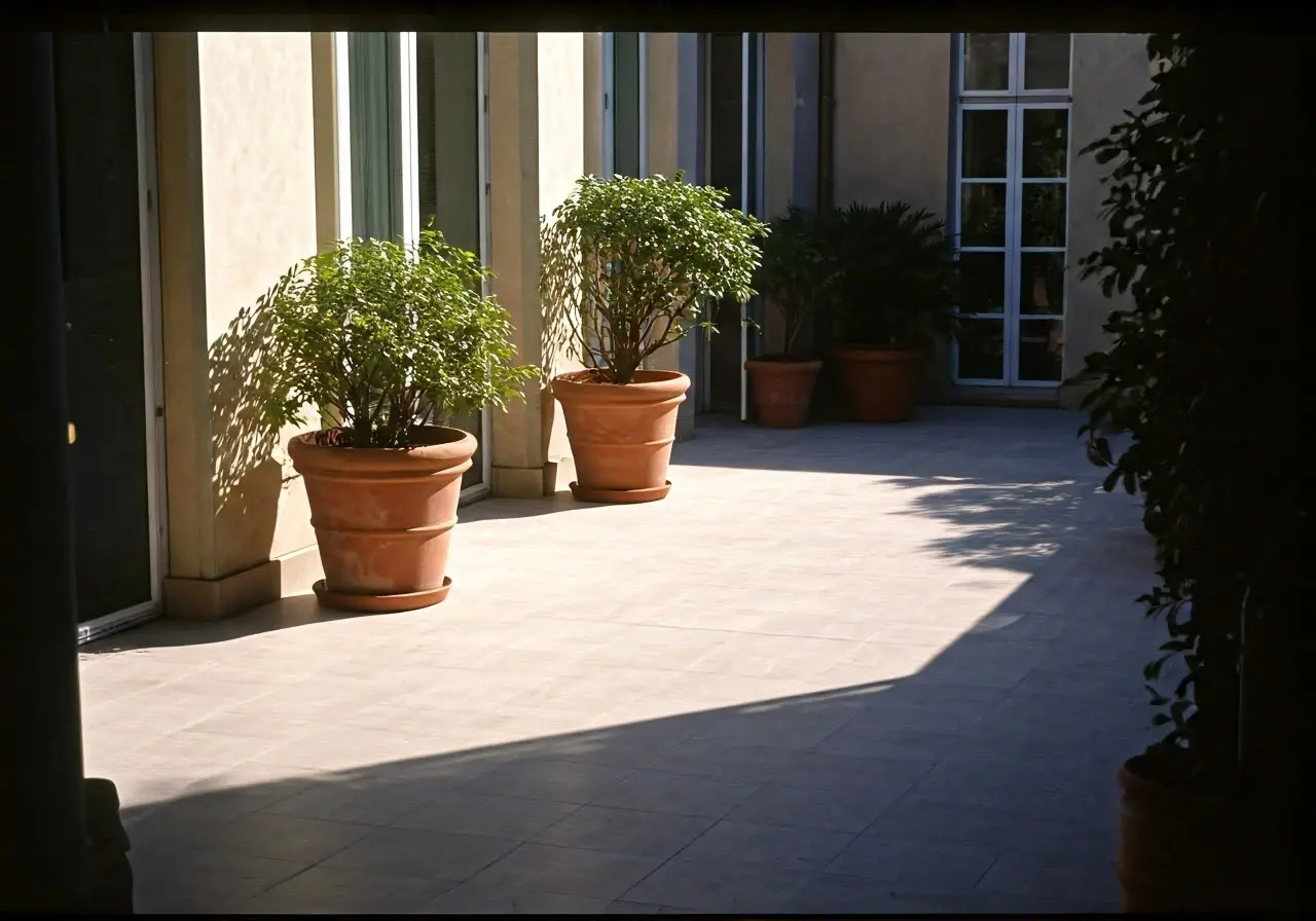 Sunlit patio with sleek porcelain tile flooring and potted plants. 35mm stock photo