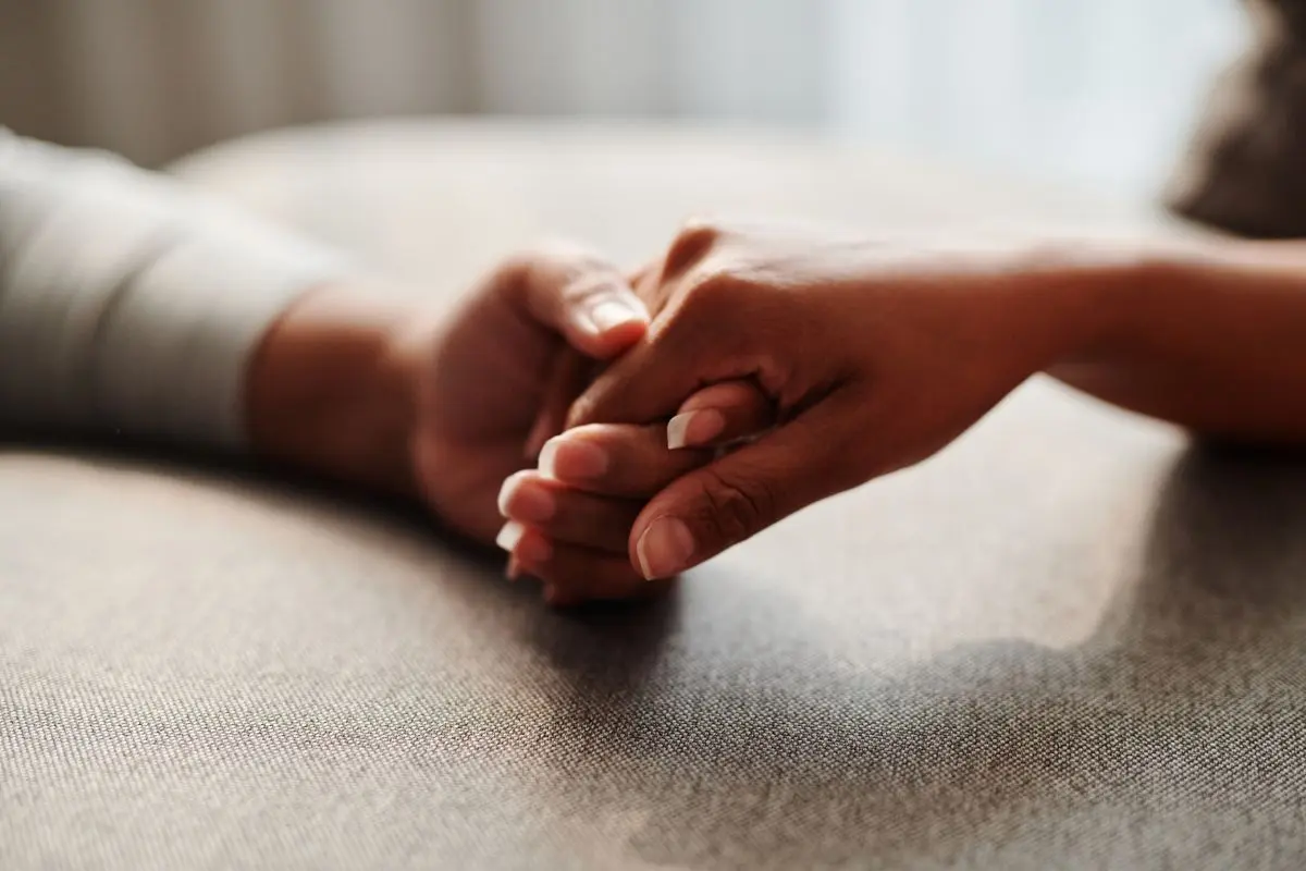 A close-up shot of two hands holding, symbolizing connection and support.