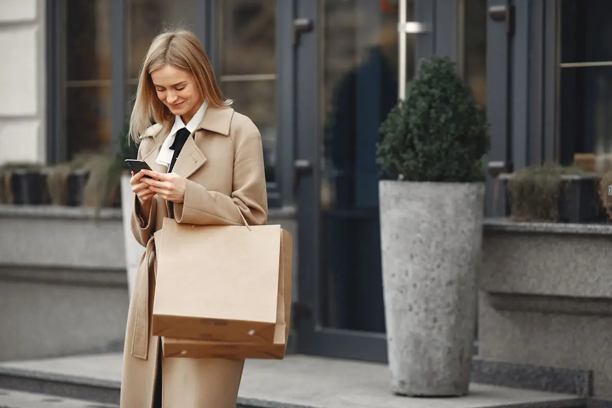 Woman with shopping bag looking at phone