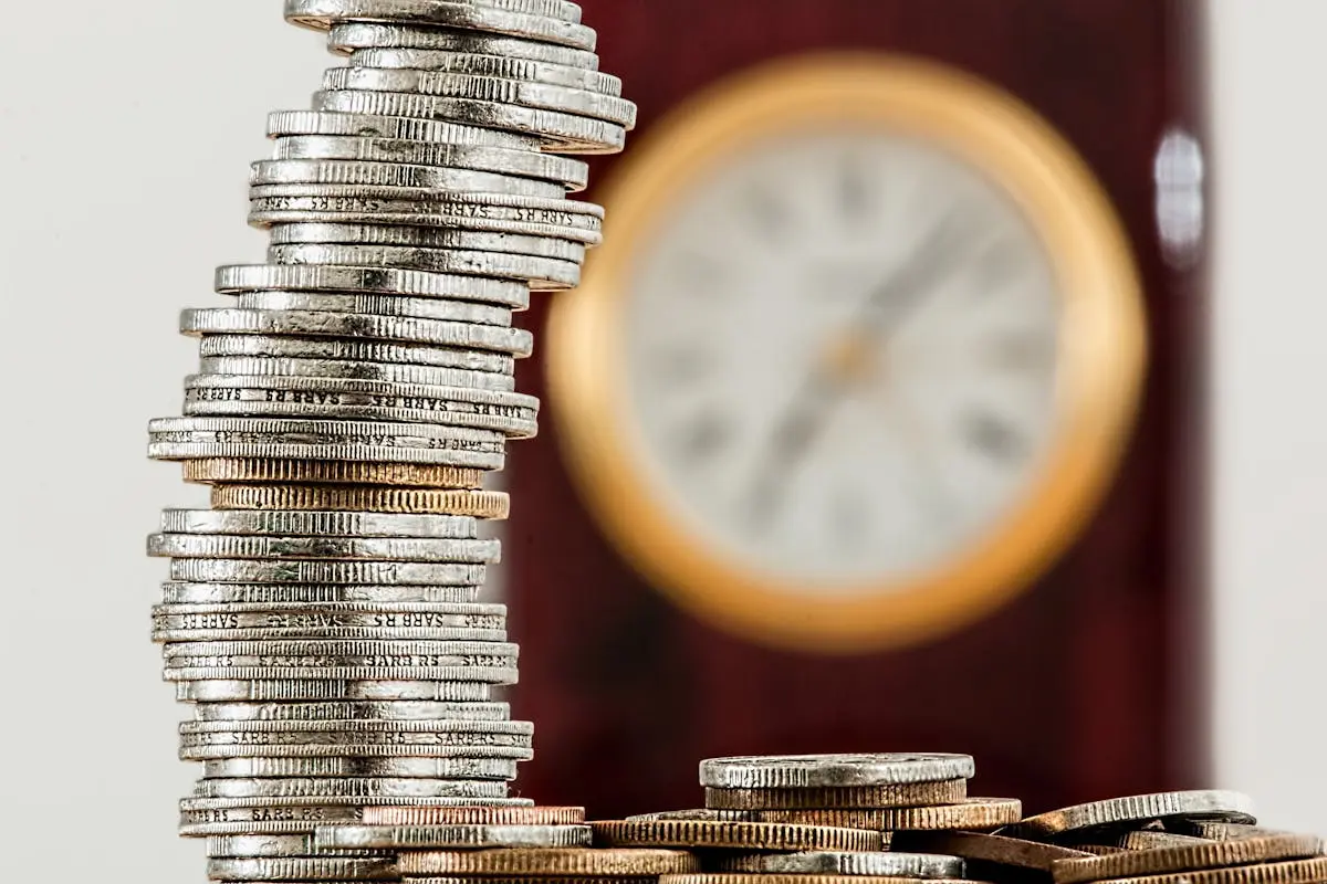A close-up image of stacked coins with a blurred clock, symbolizing time and money relationship. How to Buy a Small Business with No Money