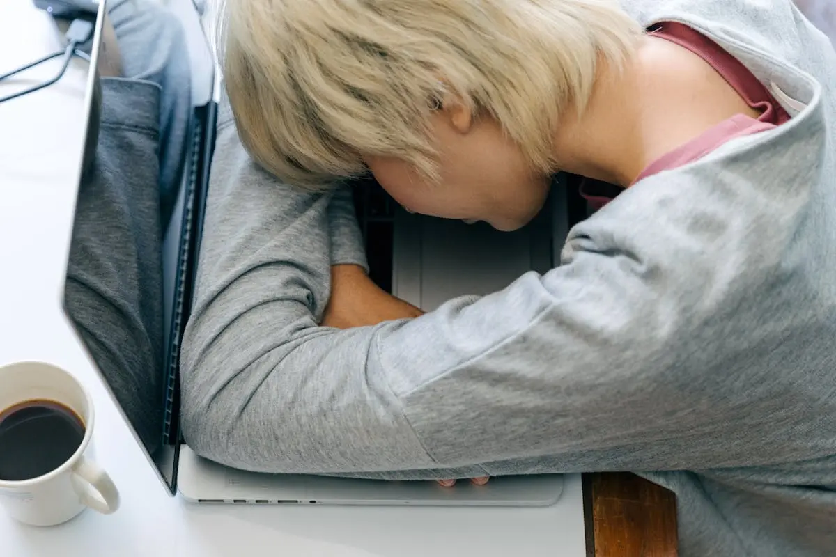 Crop woman sleeping on laptop keyboard