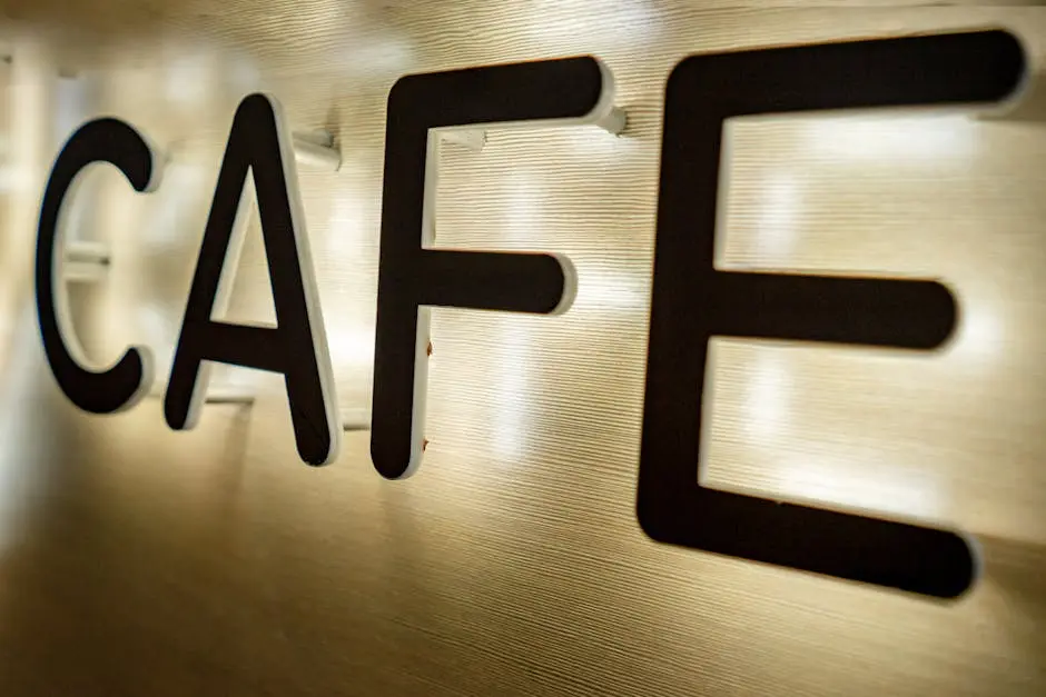 Close-up of a modern illuminated café signboard with LED backlighting, highlighting sleek design.