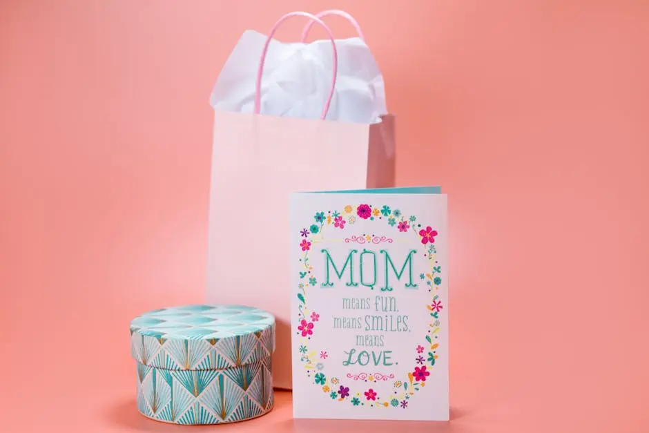 Elegant Mother’s Day greeting card with gift bag and decorative box on pastel pink background.