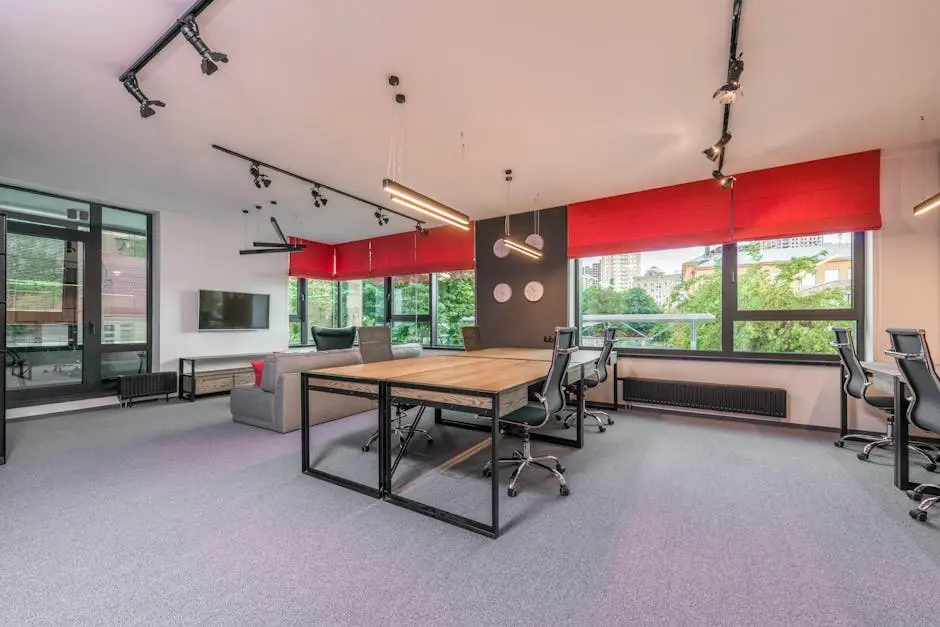 Spacious modern office space featuring red blinds, sleek desks, and ergonomic chairs.