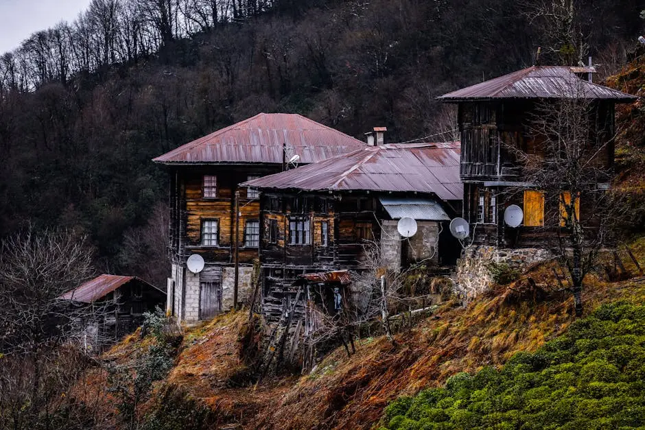 Charming wooden houses on a hillside, showcasing rustic architecture during autumn.