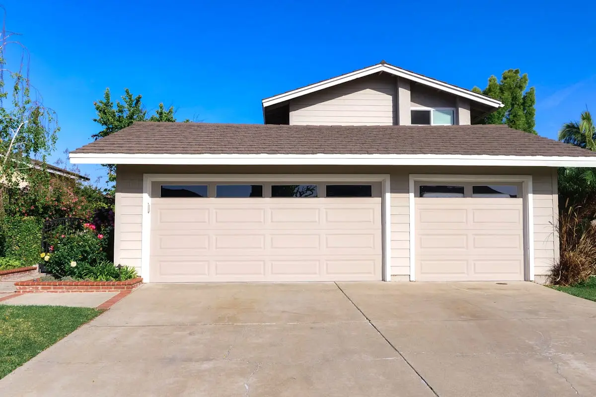 Exterior view of a cozy suburban house with a double garage, perfect for families.