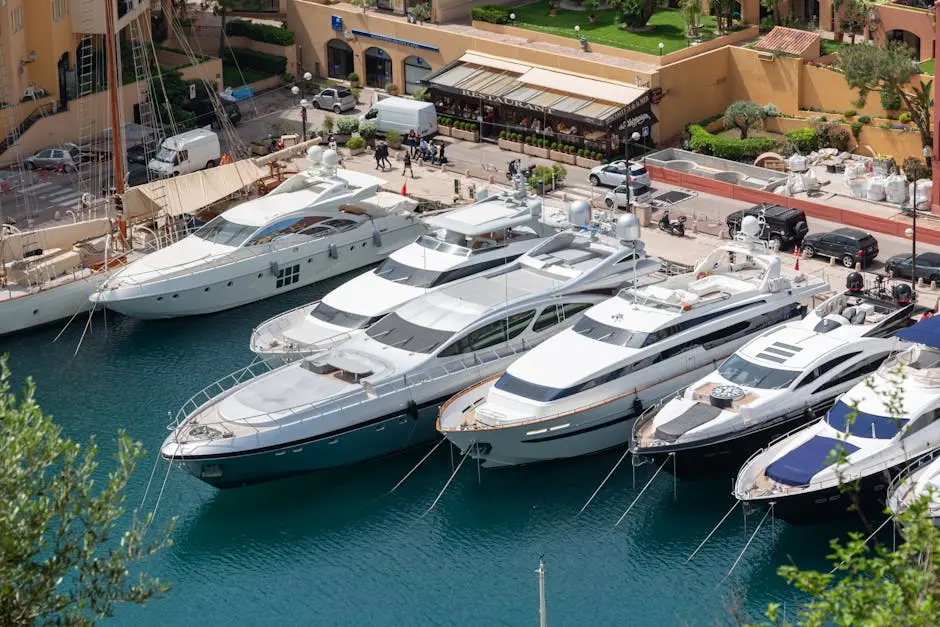 Aerial view of luxury motor yachts moored at a beautiful marina with vibrant surroundings.