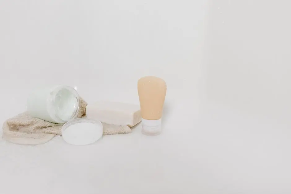 Minimalist setup of skincare products including cream, soap, and lotion on a white surface for beauty and self-care themes.