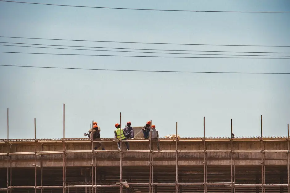 Construction workers on scaffold against a clear sky in Nairobi, Kenya.