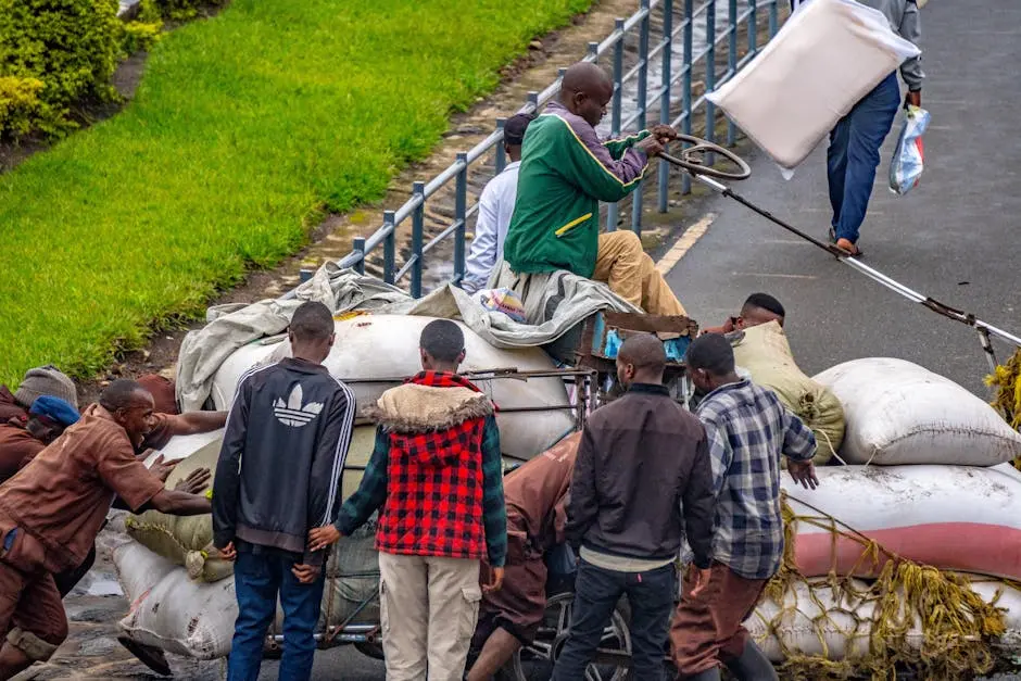 Men transporting goods in a large cart, showcasing teamwork and effort on a city street.