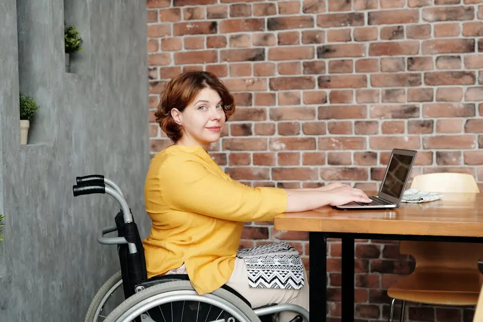 A woman in a wheelchair working remotely on a laptop in a cozy home environment.