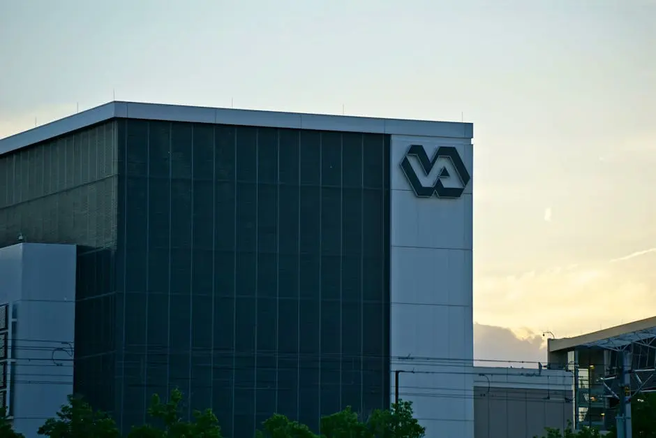 A modern building featuring a prominent VA sign, captured at sunset.