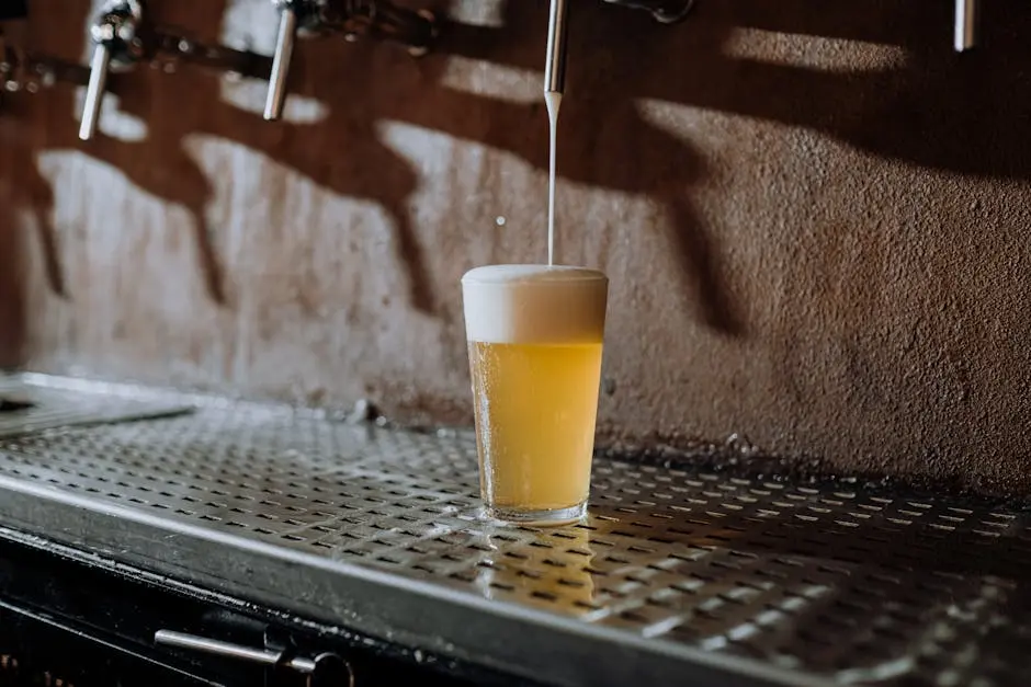 A glass of refreshing cold beer being poured from a tap in a cozy bar setting.