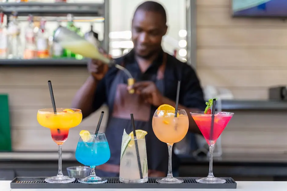 Bartender expertly crafting vibrant cocktails at a modern bar setting, showcasing colorful drinks.