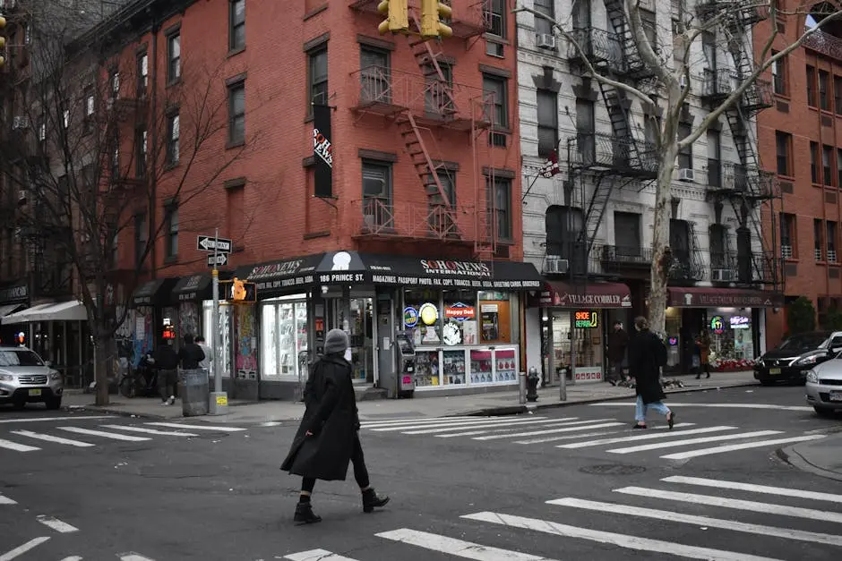 Pedestrians crossing a street at an intersection in Brooklyn, NYC with shops and apartments.