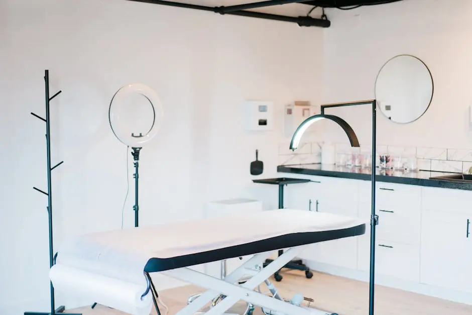 Bright and modern medical spa room featuring massage bed and studio lighting.