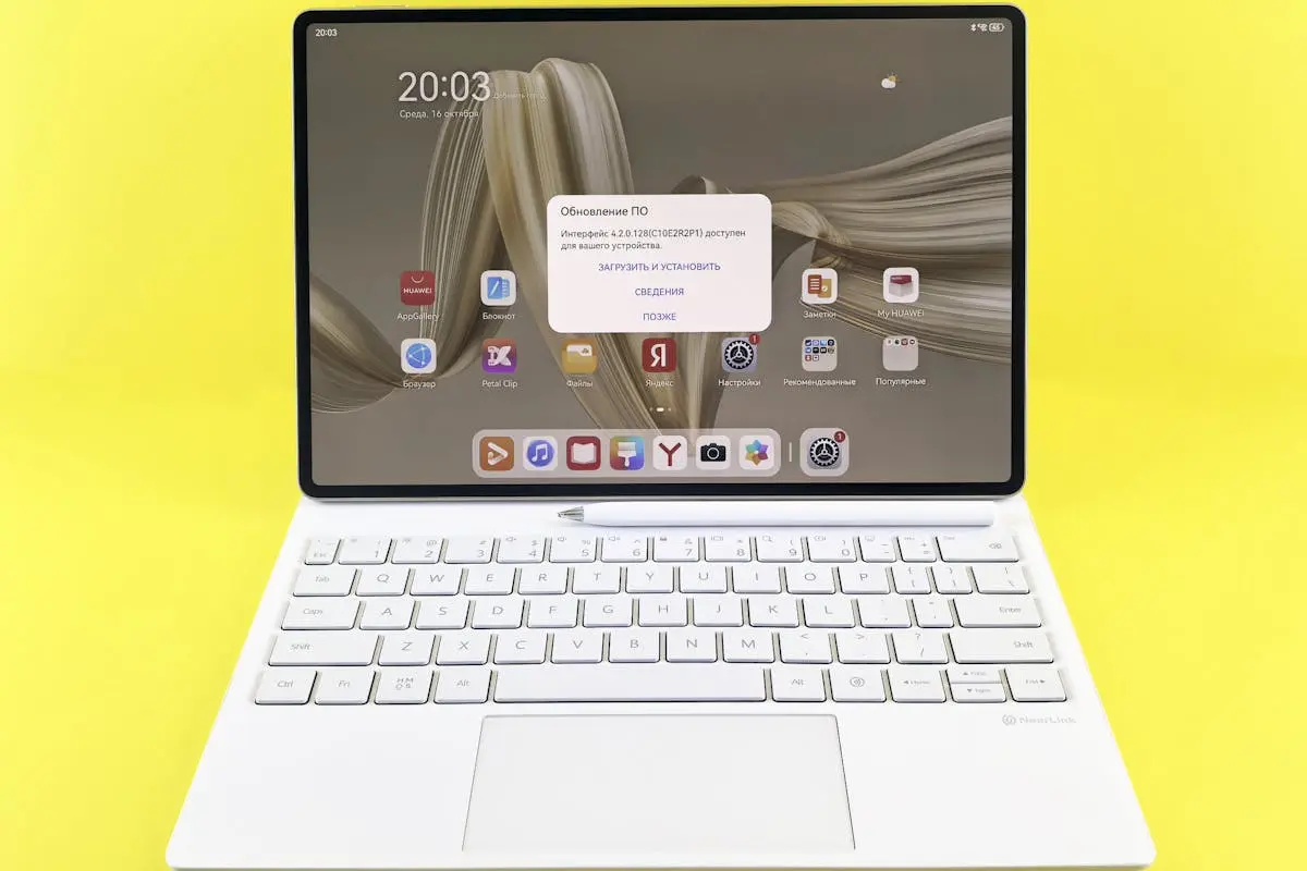 Sleek tablet with keyboard displaying a screen update prompt on a vibrant yellow background.
