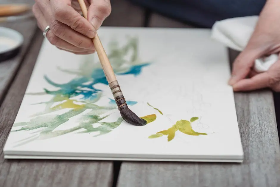 Artist’s hands painting vibrant watercolor art in a sketchbook, capturing creativity and detail.
