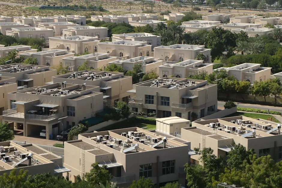 Aerial view of modern residential villas surrounded by greenery in Dubai.