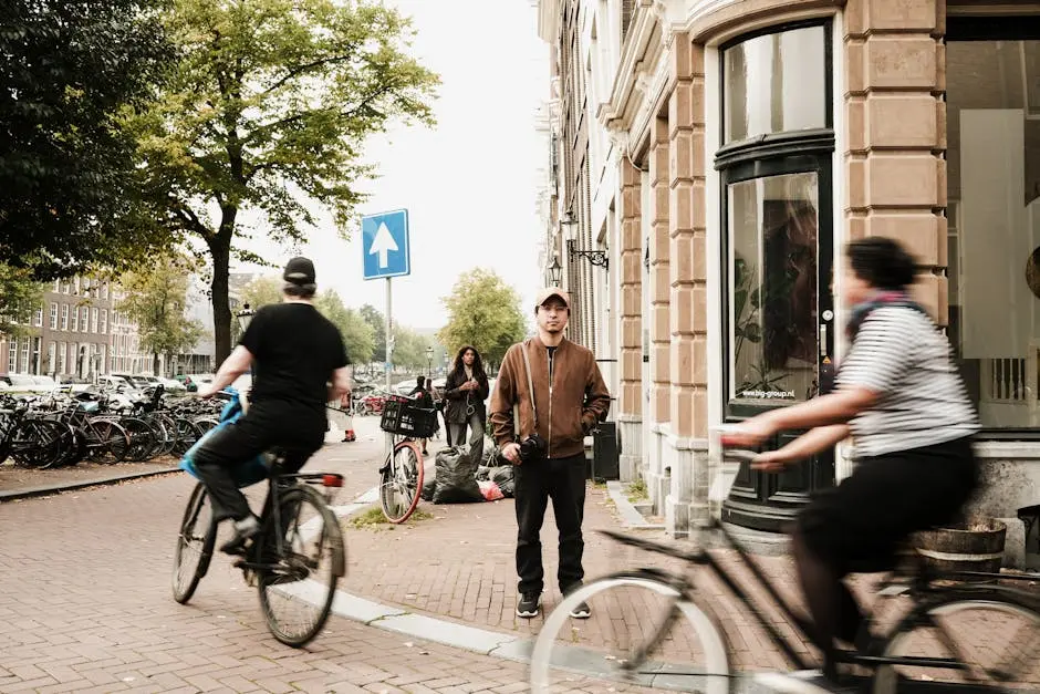 Cyclists ride through a bustling Amsterdam street, capturing the essence of urban life and urban backpack in the Netherlands.