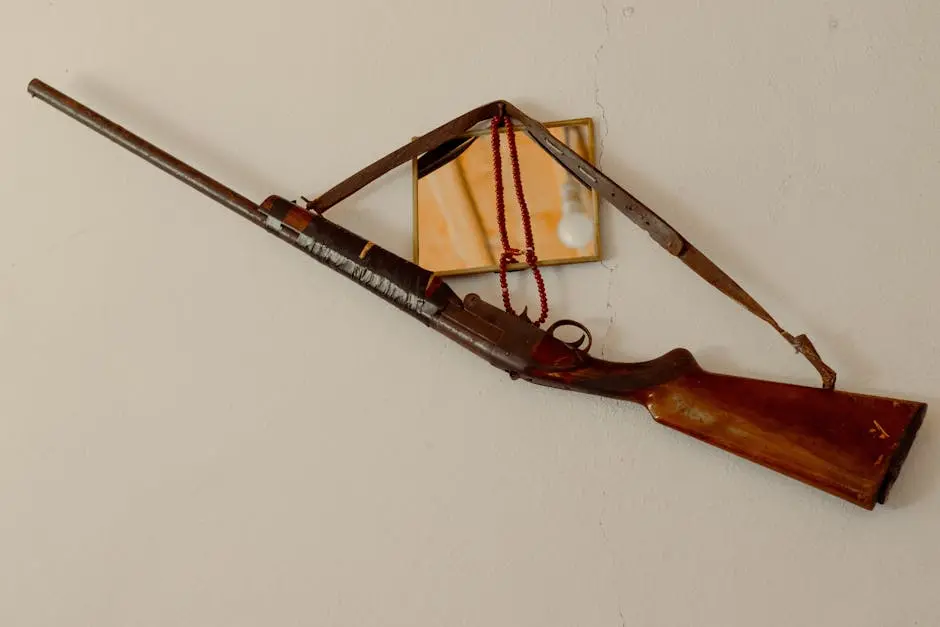 Antique rifle hanging on a wall, complemented by a small mirror reflection.