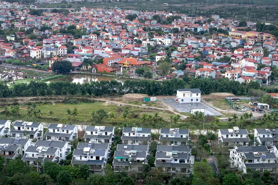 Drone view modern residential cottages located on grassy suburb district of modern town on summer day