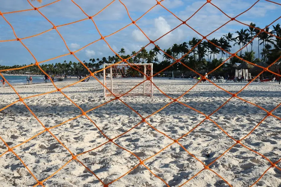 Orange soccer net on a sandy beach in Punta Cana, Dominican Republic, perfect for a tropical sports setting.