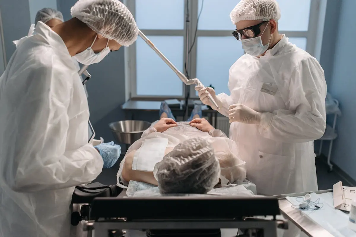 Surgeons in sterile gowns performing surgery in a modern operating room.