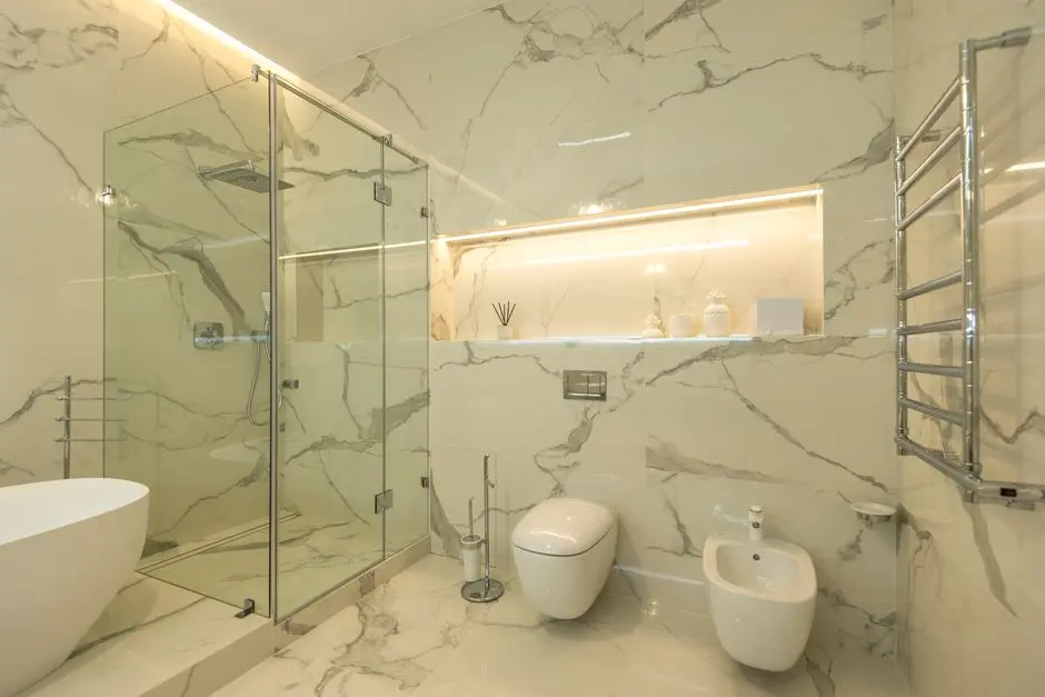 Elegant luxury bathroom featuring marble walls, a glass shower, and modern fixtures.