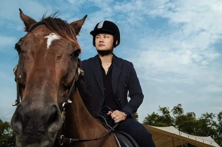 Man in helmet riding a brown horse under blue sky, showcasing equestrian style and outdoor adventure.