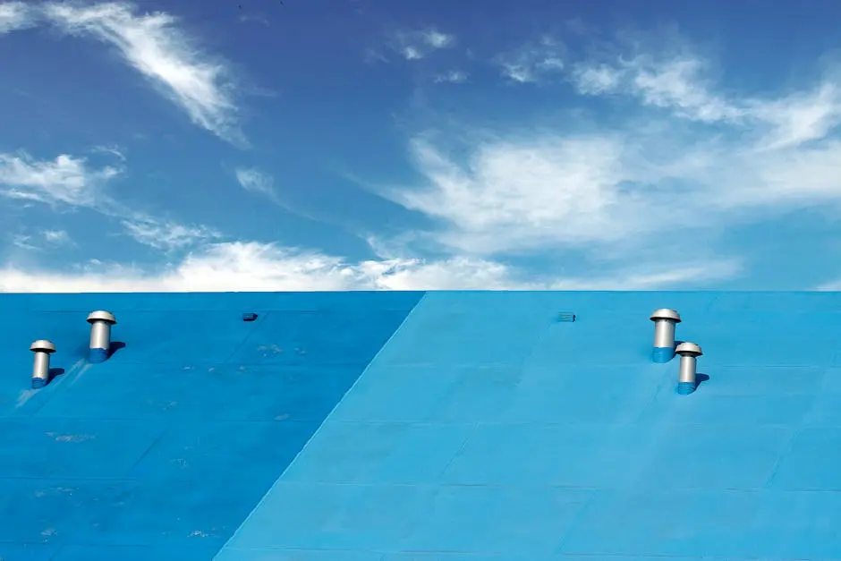 A vibrant blue roof with chimneys under a clear blue sky with scattered clouds, captured outdoors.