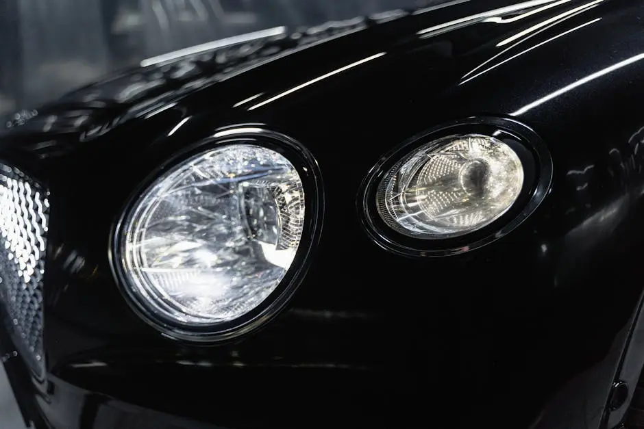 High-quality close-up of a luxury car’s polished black headlights.