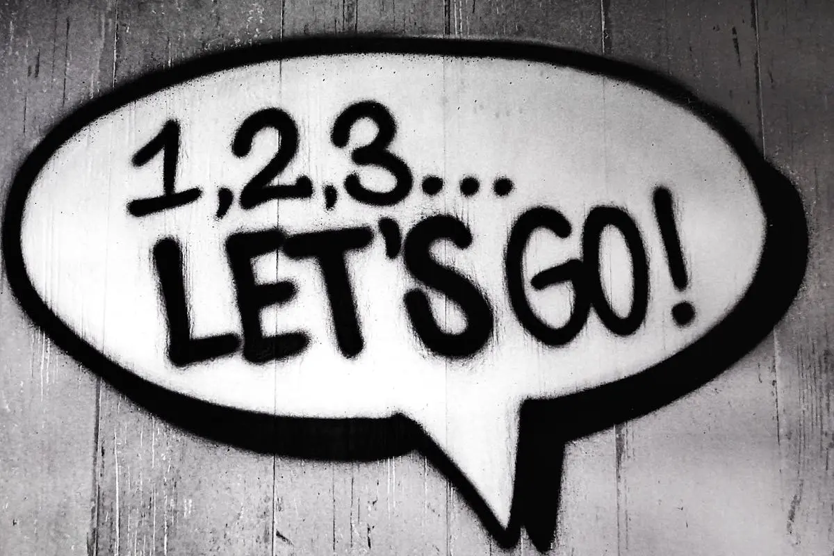 Black and white street art featuring a bold motivational message in a speech bubble.