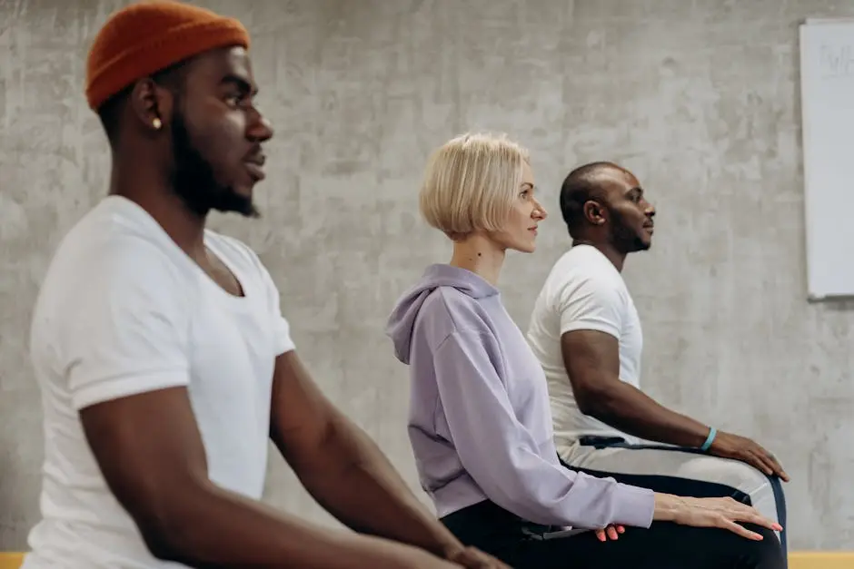 Three people practicing meditation indoors, focusing on relaxation and wellness.