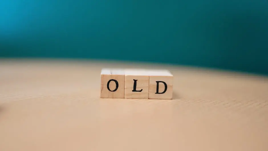 Wooden blocks on a table spelling OLD with a plain background.