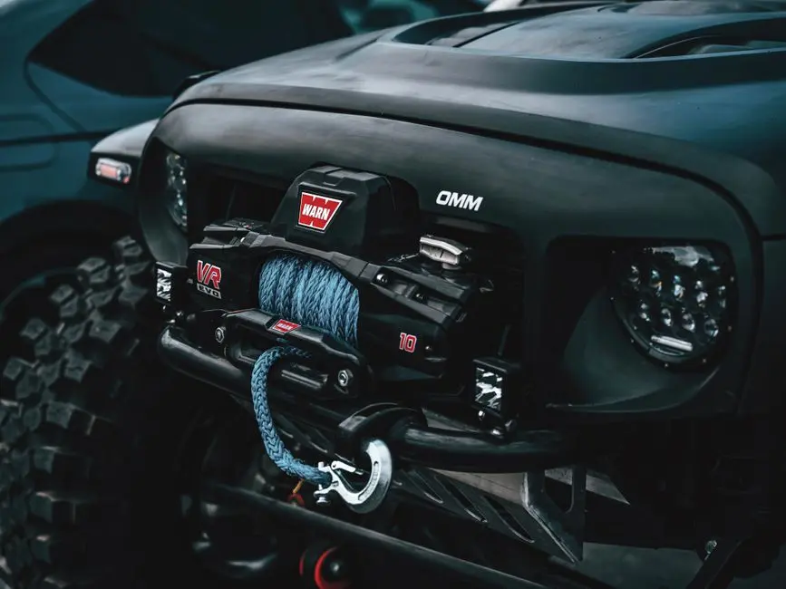 Detailed view of a rugged off-road vehicle featuring a front-mounted winch system, ideal for adventurous terrains.