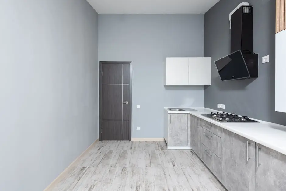 Spacious minimalist kitchen with modern appliances and marble countertops.