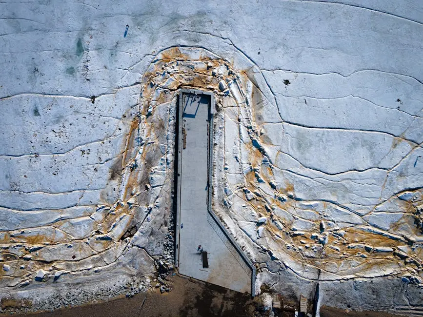Aerial shot of a weathered concrete structure surrounded by cracked earth.