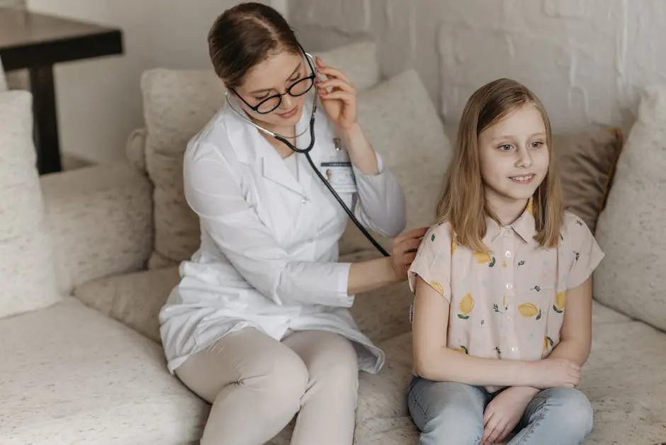 Doctor using a stethoscope for a child’s check-up on a sofa during a home visit.