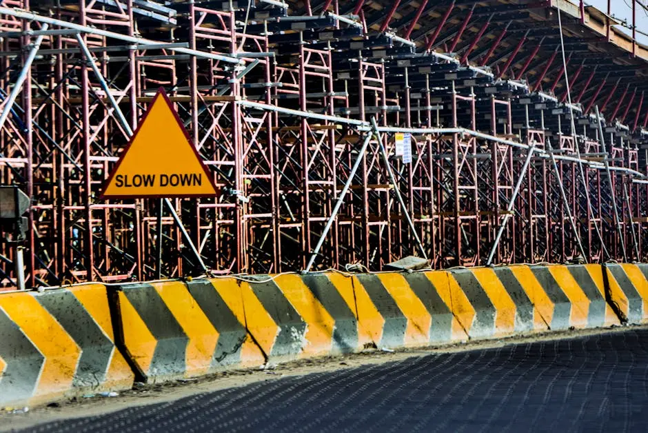 Construction site with a &lsquo;Slow Down&rsquo; sign amid scaffolding in Kuwait.