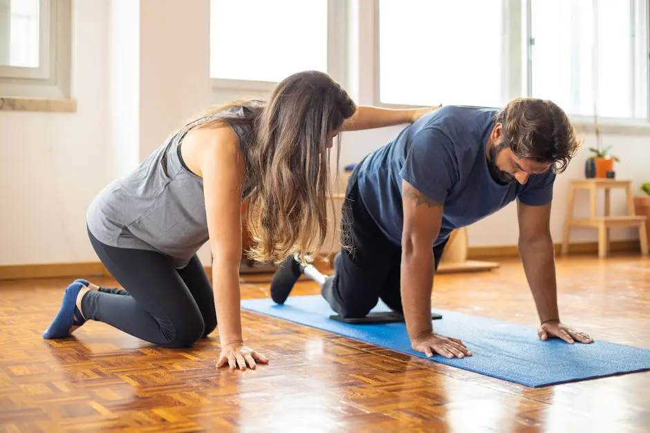 A man with a prosthetic leg exercises with a trainer indoors for adaptive fitness.