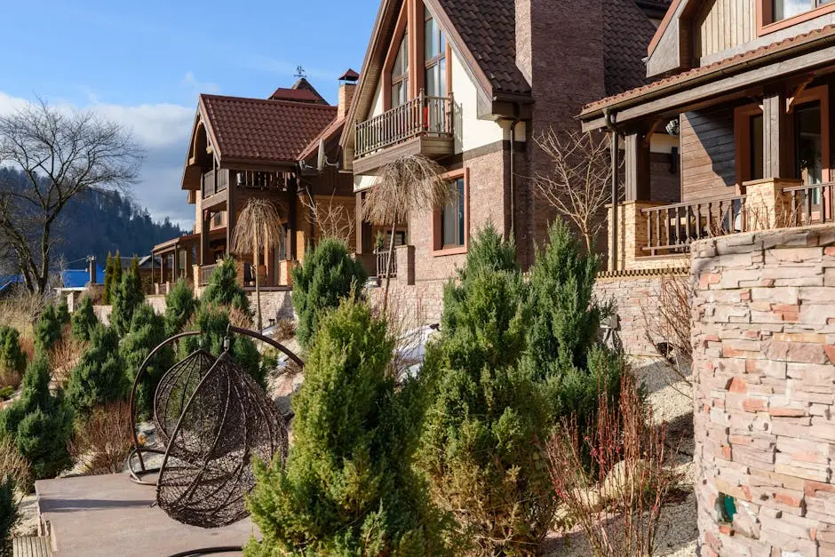 Charming mountain chalets with rustic facades amidst lush greenery in a serene outdoor setting.