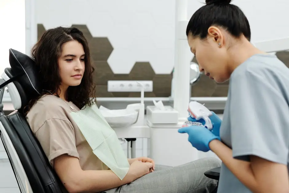 A female dentist showing a dental model to a patient during a consultation in a modern office.