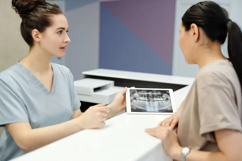 A dentist explains X-ray results to a patient using a tablet in a modern dental clinic.