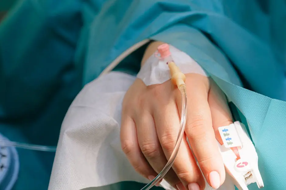Close-up of a patient’s hand with intravenous therapy and pulse oximeter, symbolizing healthcare and treatment.